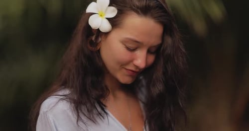 Young Woman Smiles With Flower in Her Hair