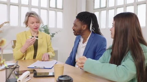 Financial Advisor Consulting Young Couple in Modern Office