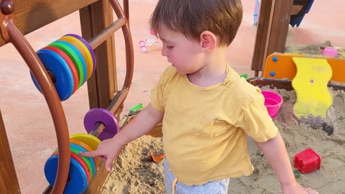Ein Kind spielt auf dem Spielplatz mit Rechnungen, lernt zählen. Baby im Alter von zwei Jahren (zweijähriger Junge
)