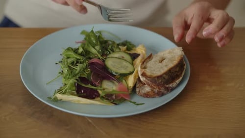 Closeup of a Woman Who Has Breakfast with Vegetable Salad and a Slice of Bread Healthy Food Concept
