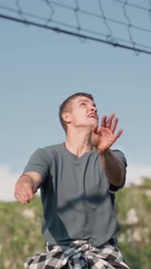 Young Man Plays Volleyball Outdoors During Sunny Day