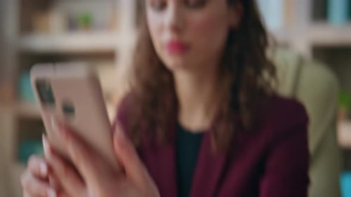 Woman Works at Desk While Using Mobile Phone