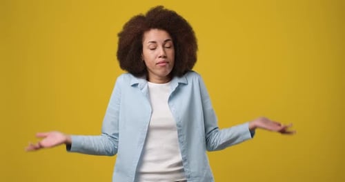 Confused Doubtful Young African American Woman Looks with Puzzled Face Shrugs Shoulders Showing Not