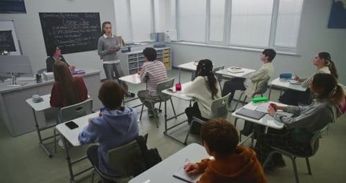 Teen Students Listening to Teacher in Classroom
