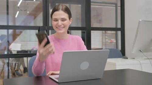 Woman Answers Phone in Modern Office Setting