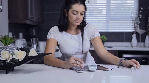 Young Woman Uses Tablet in Modern Kitchen