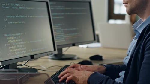 Focused developer coding software in office on desktop computer slow motion