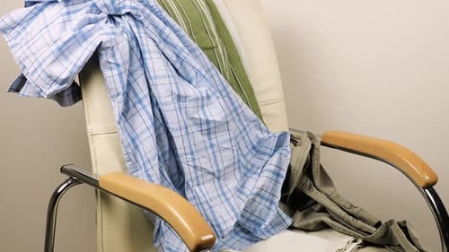 Clothes Piled on White Leather Office Chair