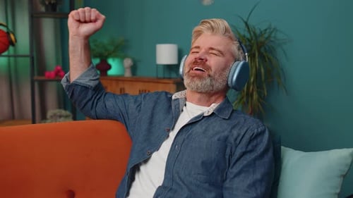 Man Enjoys Music with Headphones on Couch