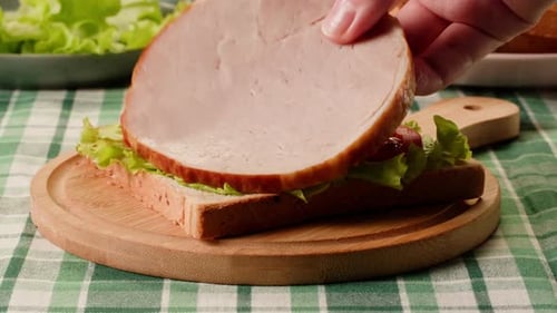 Delicious Sandwich Being Assembled with Meat and Cheese