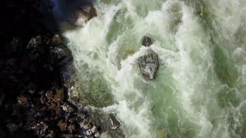River Current Flowing in the Valley Around the Smooth Rocks During a Bright Sunny Spring Day