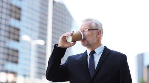 Mature businessman drinking coffee outside in the city