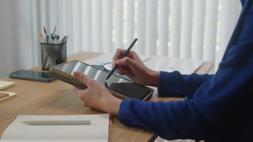 Woman Using Stylus and Tablet at Desk