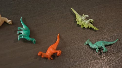 pequeños dinosaurios de juguete de plástico esparcidos por el suelo de la sala de estar de la casa