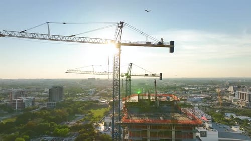 Tower Lifting Cranes at High Residential Apartment Building Construction Site Real Estate