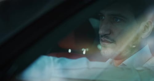 Intense Man Driving at Night in the City