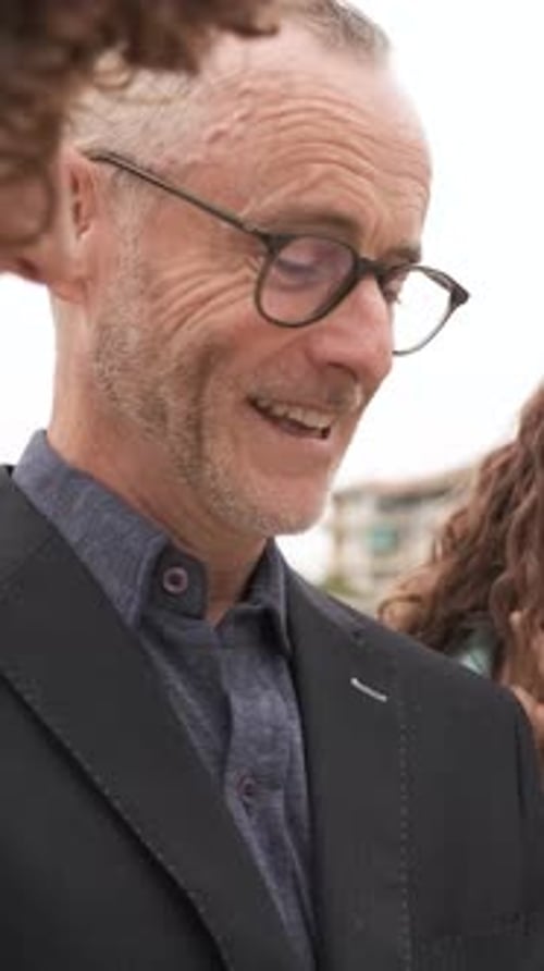 Businessman Actively Engaging with Colleagues During a Professional Meeting Vertical