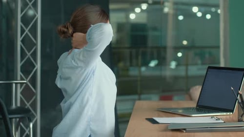 Tension Relief: Woman Massages Neck at Desk