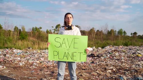 Woman Holding Save the Planet Sign in Landfill