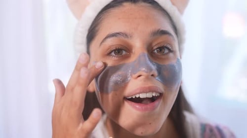 Brunette Woman Applying a Cosmetic Face Mask