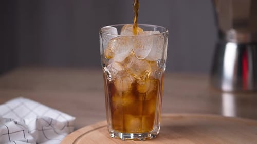 Coffee being poured into a Glass with Ice
