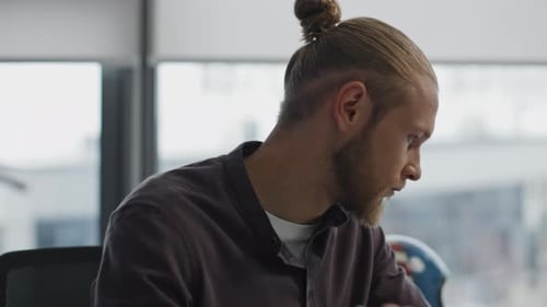 Thoughtful young man pondering project ideas at remote workplace home portrait