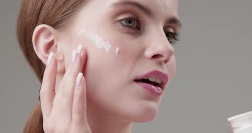 Woman Applying Cream to Face for Skincare