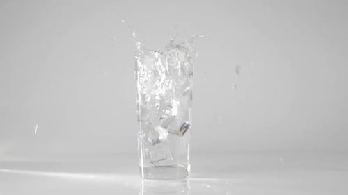 Ice Cubes Splashing into Glass of Water