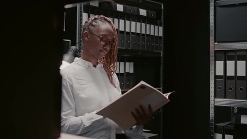 Young Adult Reviews File in Office at Night