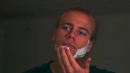 Young Adult Applying Shaving Cream to Face