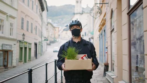 Delivery Man Courier With Face Mask Delivering Groceries In Town.