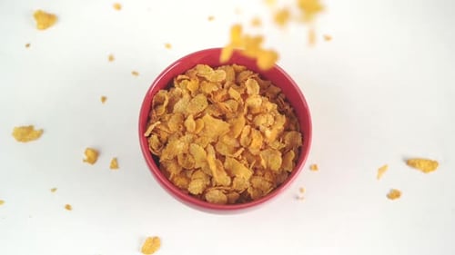 Top view of cornflakes being poured in a bowl in slow motion