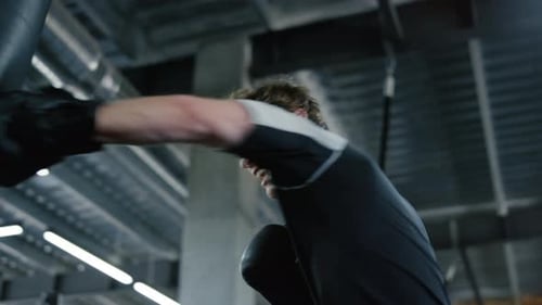 Energetic natural kickboxer training with purpose at the gym in slow motion