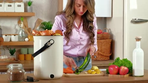 Woman peeling vegetables and recycling organic waste in the kitchen