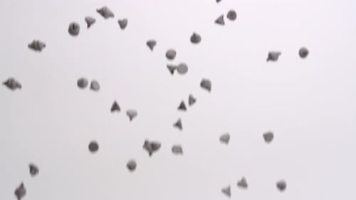 Semi sweet chocolate chips dessert raining down on white backdrop in slow motion