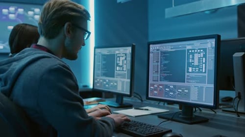 Software Developers Coding At Desks In Modern Office