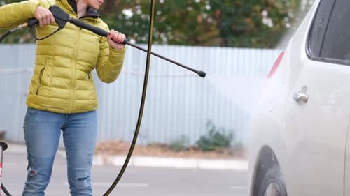 Woman Washing Car with Pressure Washer