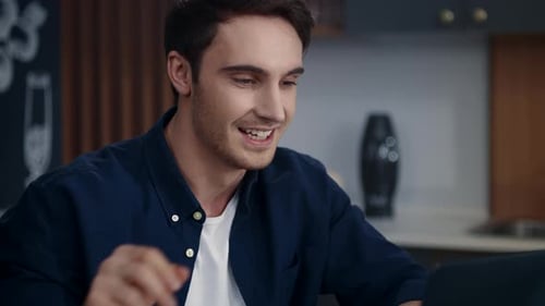 Young Man Working on Laptop and Drinking Coffee