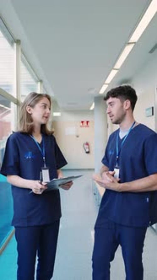 Medical Professionals Discussing Patient Information in Hospital Hallway