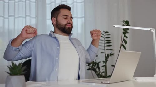 Produktiver Mann macht Pause, um sich während des Arbeitstages am Desktop zu dehnen