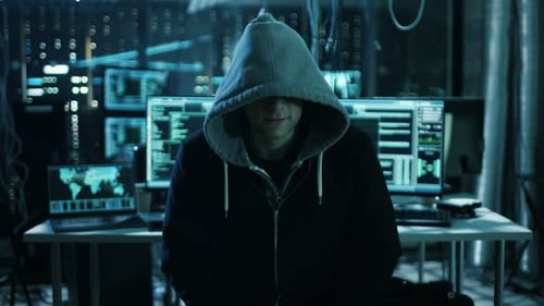 Gefährlicher international gesuchter Hacker spricht in die Kamera. Im Hintergrund sein Operating Ro