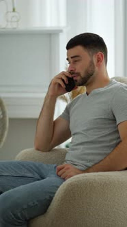 Man Talking on Smartphone Sitting in Armchair