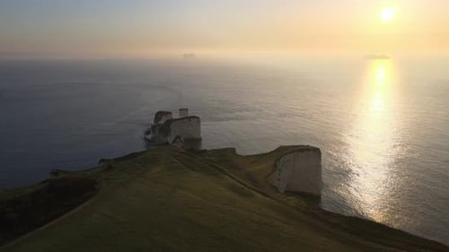 Drone view of Old Harry Rocks stunning cliff at sunset. Aerial forward