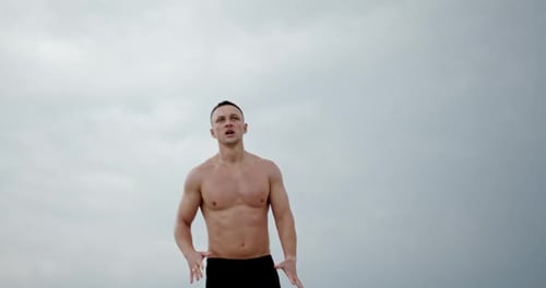 Man Exercising Outdoors Against Light Gray Sky
