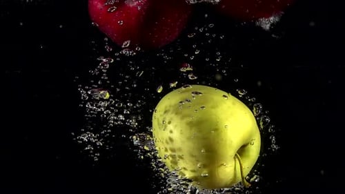 Slow Motion Red Apple Falling Underwater Water on Black Background