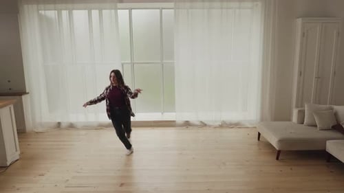 Woman Dancing Joyfully in Bright Modern Home