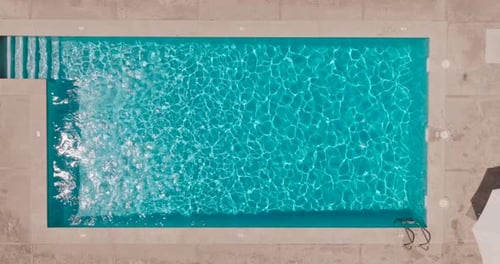 Blue Water in the Swimming Pool with Light Reflections