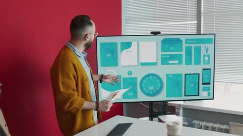 Man Presenting Branding Mockups to Small Group