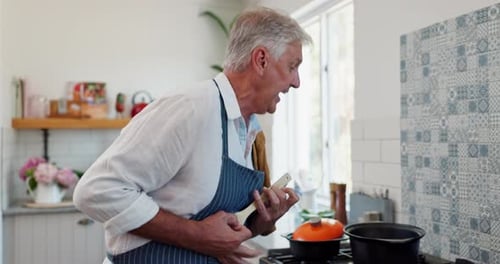 Man Singing with Wooden Spoon in Kitchen