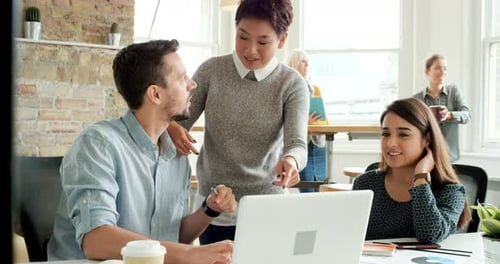 Colleagues Working Together on Laptop in Bright Office